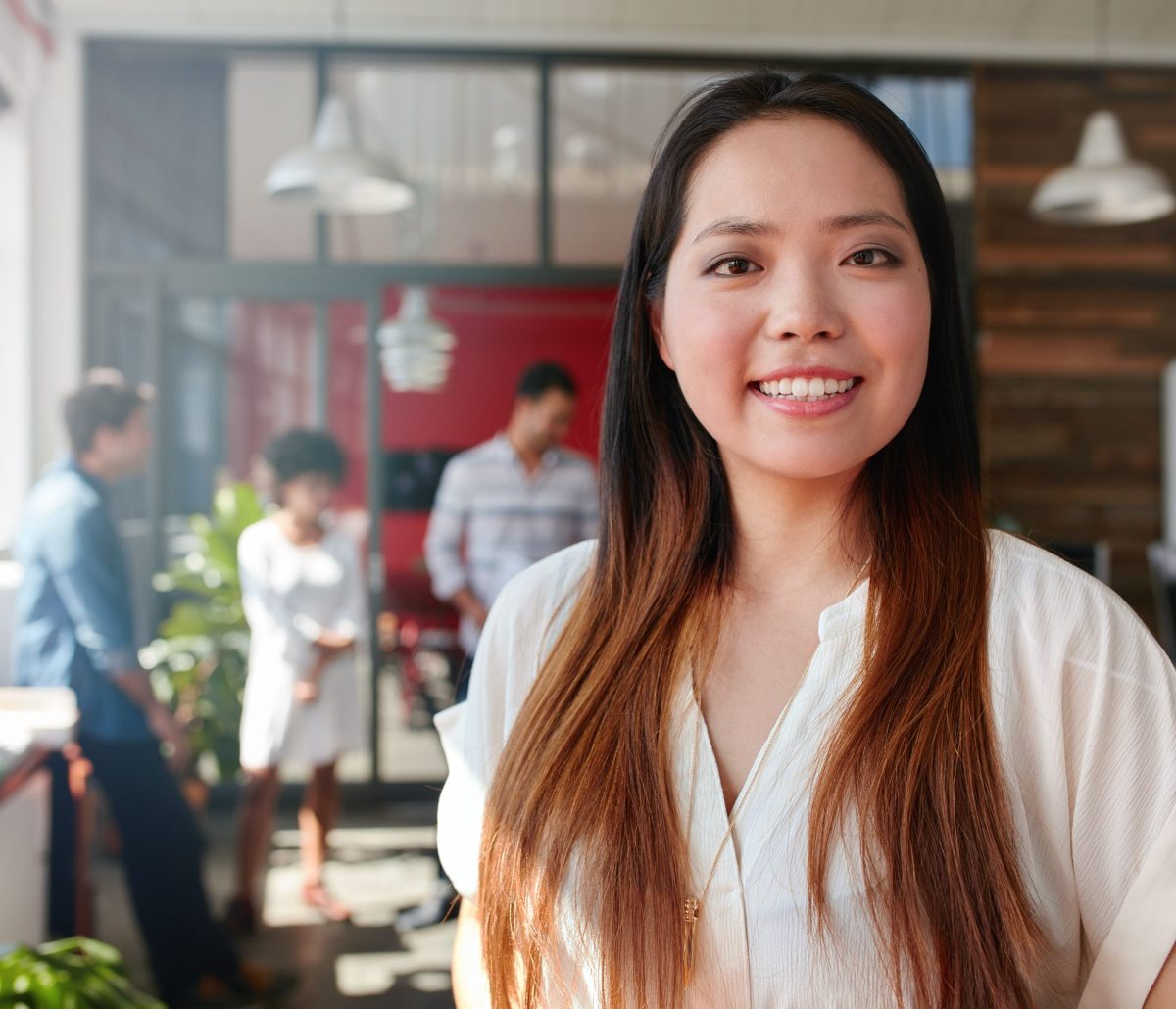 smiling-young-businesswoman-in-office-P7BUN7K-scaled.jpg